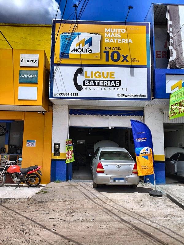 Fachada da Ligue Baterias com moto estacionada na frente